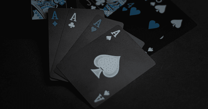 Black, white, and blue playing cards on a black surface