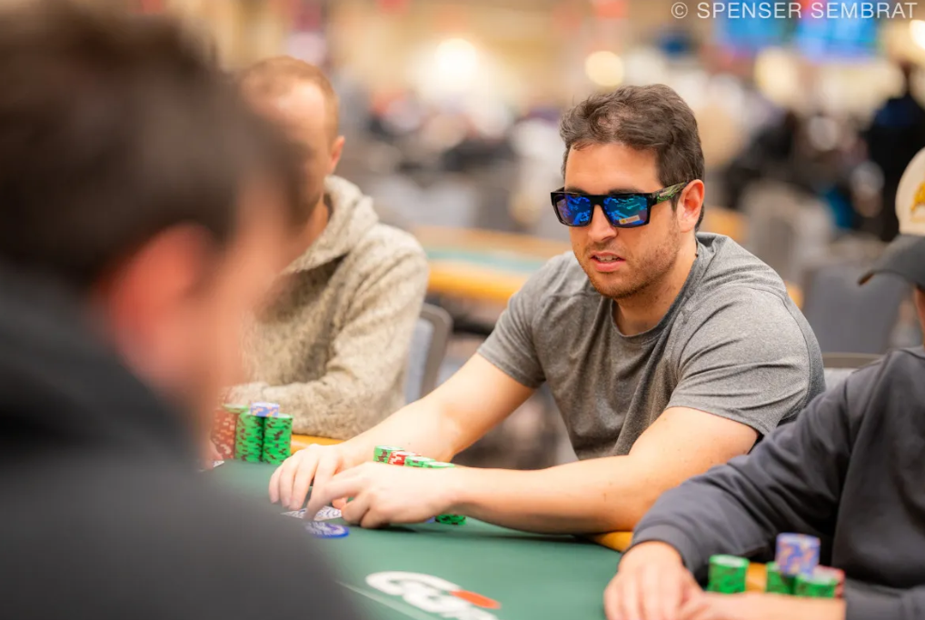Michael Hawker plays at the WSOP Main Event, wearing reflective sunglasses and a gray t-shirt, moments before his dramatic Day 5 bustout.